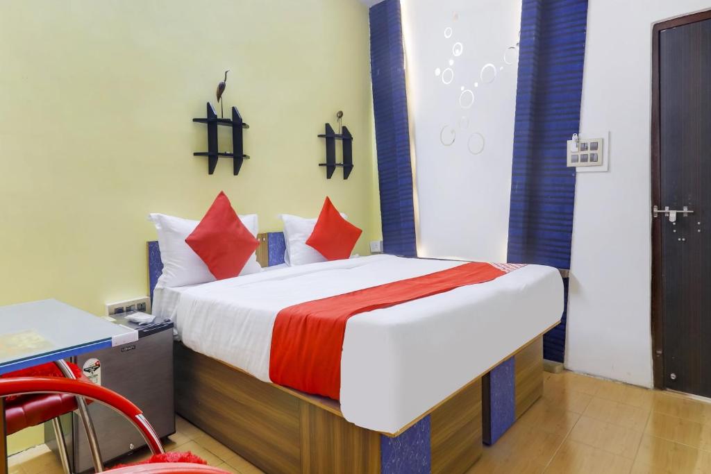 a bedroom with a large bed with red pillows at Super OYO Flagship Relax Grand Near Snow World in Hyderabad