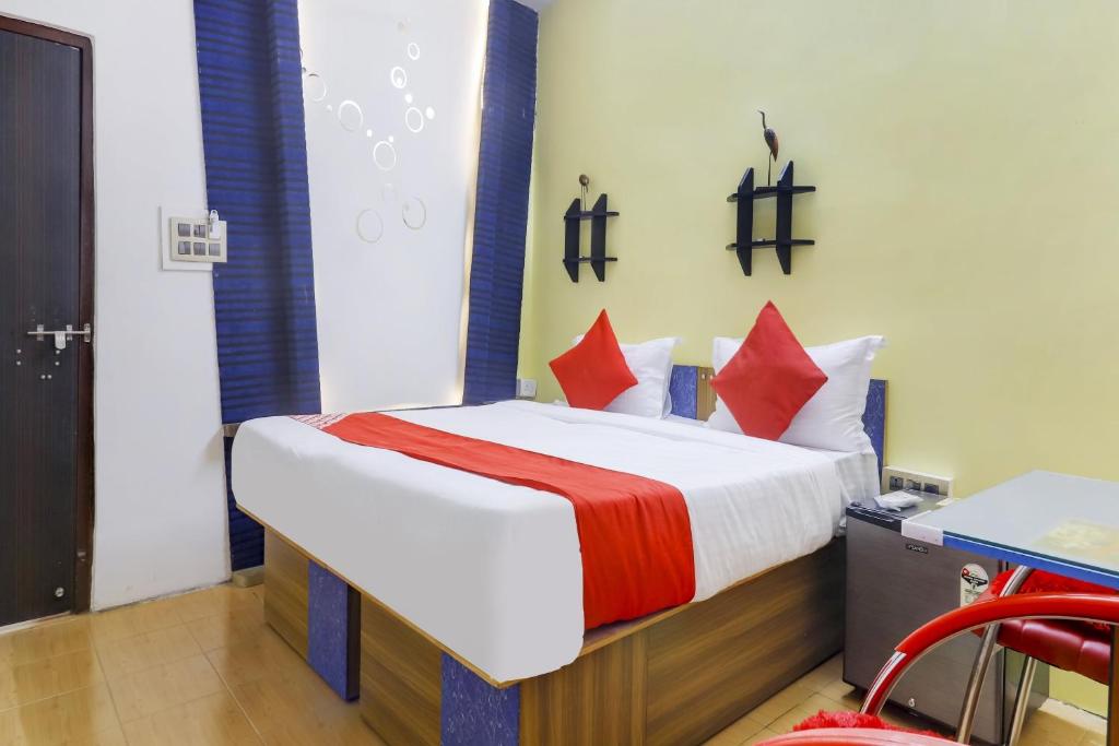 um quarto com uma cama com almofadas vermelhas em Super OYO Flagship Relax Grand Near Snow World em Hyderabad