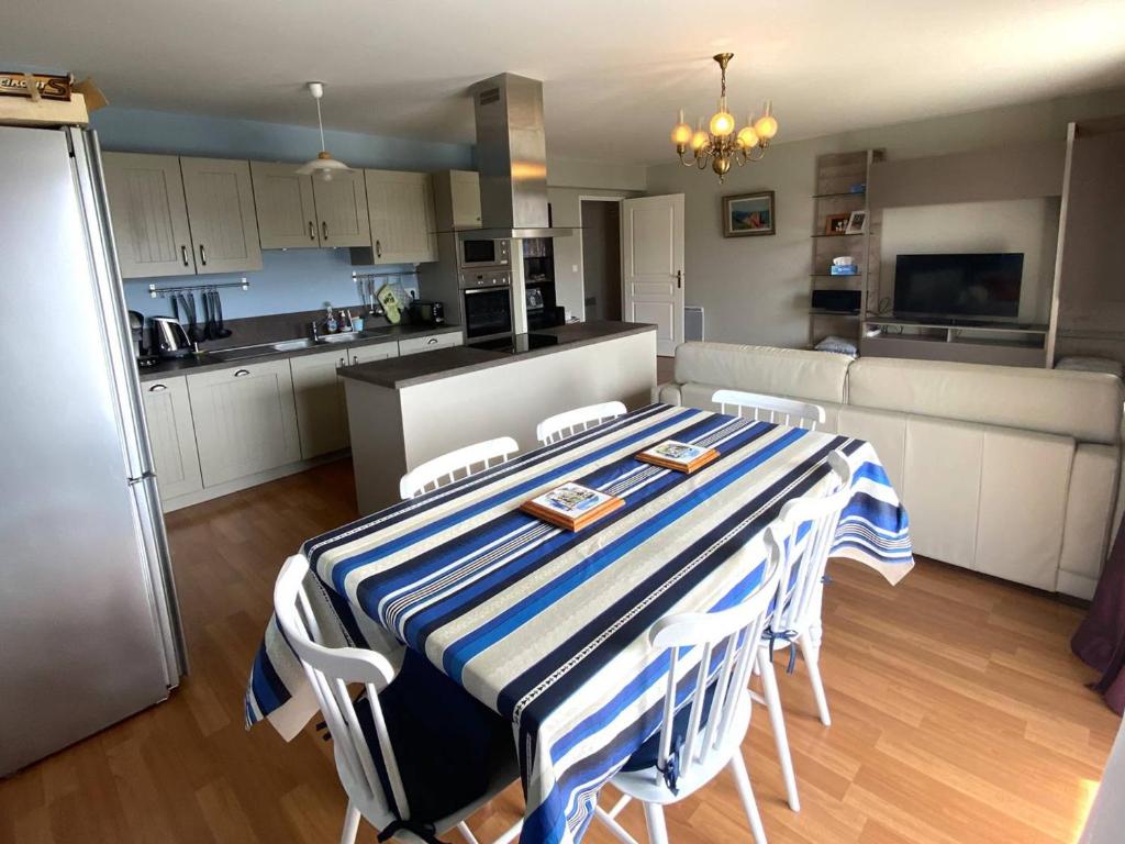 une cuisine avec une table avec un tissu de table rayé bleu et blanc dans l'établissement Appartement au calme avec WIFI, balcon, parking au centre de Perros-Guirec, à 500m des commerces - FR-1-368-420, à Perros-Guirec