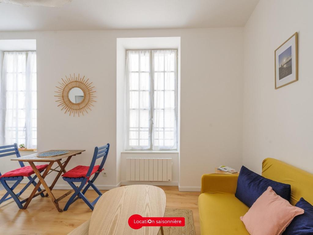 un salon avec un canapé jaune et une table dans l'établissement Appartement Charme & Confort à 10m du Vieux Port- La Rochelle, 2 Pers, Wifi & Équipements Complets - FR-1-535-56, à La Rochelle