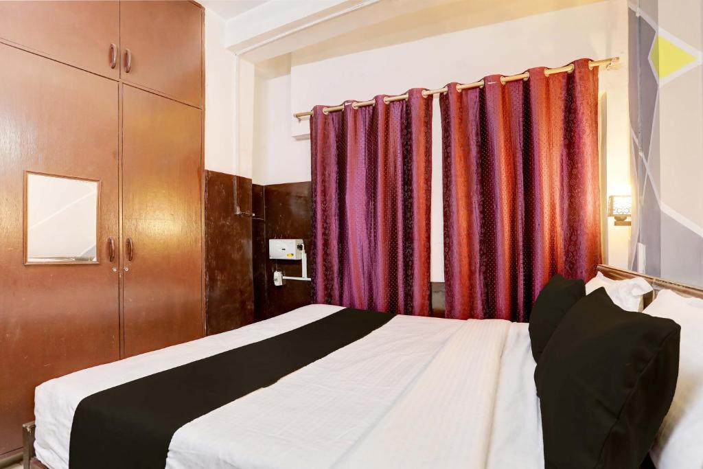 een slaapkamer met een bed en een aantal gordijnen bij Green Park Residency in New Delhi
