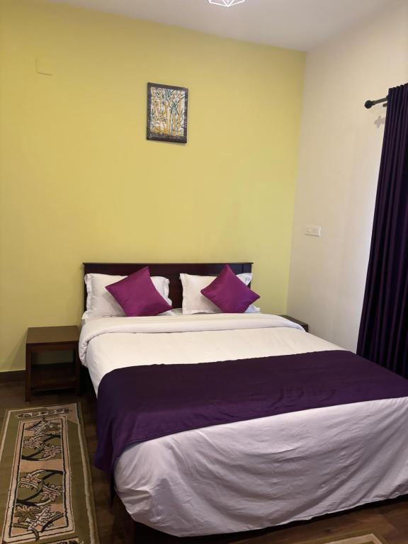 a bedroom with a large bed with purple pillows at Casa Felicia-Adding happy moments to your diary in Ooty