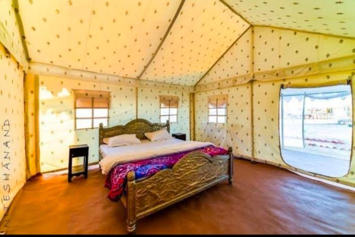 a bedroom with a bed in a tent at Sam dunes Safari Camp Jaisalmer in Sām