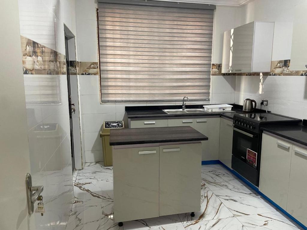 a kitchen with white cabinets and a black stove at Luxury Townhome in Oyarifa in Oyarifa