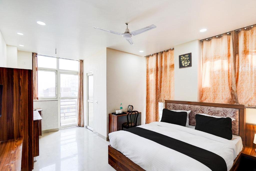 een slaapkamer met een bed en een groot raam bij Shivam Hotel in Noida