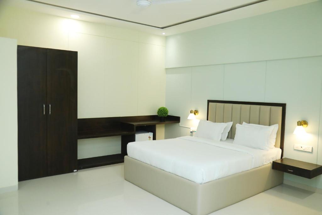 a bedroom with a large white bed and a cabinet at Andheri Sports Complex - VIP Guest House in Mumbai