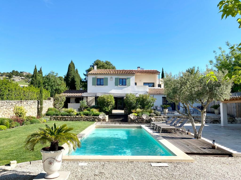 a villa with a swimming pool in front of a house at Bastide La Mérigot - Maussane-les-Alpilles in Maussane-les-Alpilles