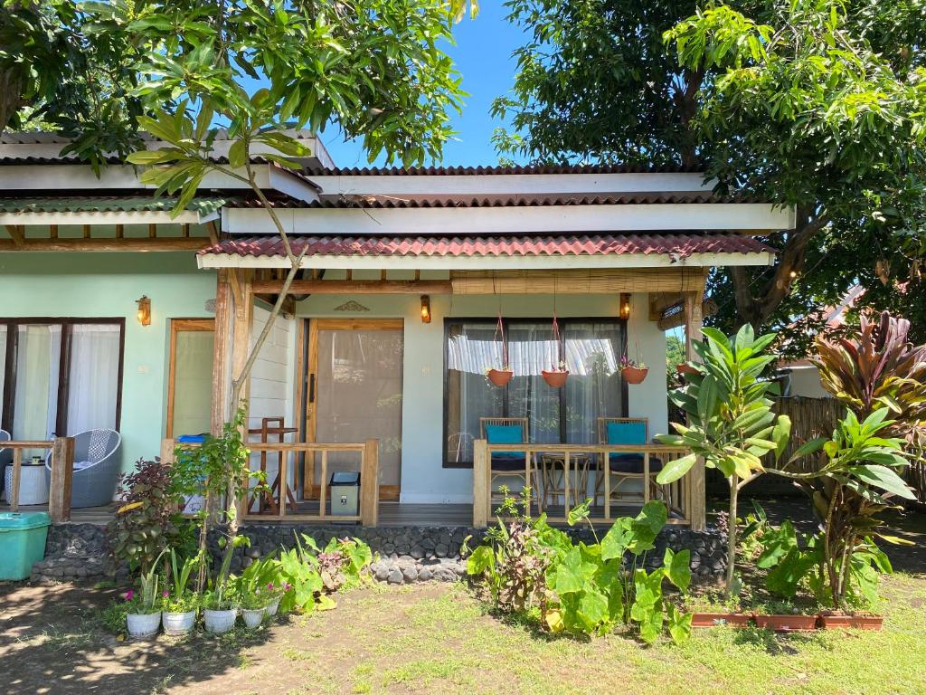 a house with chairs and plants in front of it at Marta House gili air in Tanjungkarang