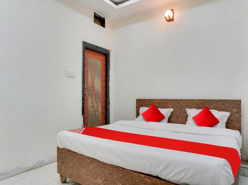 a bedroom with a large bed with red pillows at OYO Hotel Shivansh in Bhopal