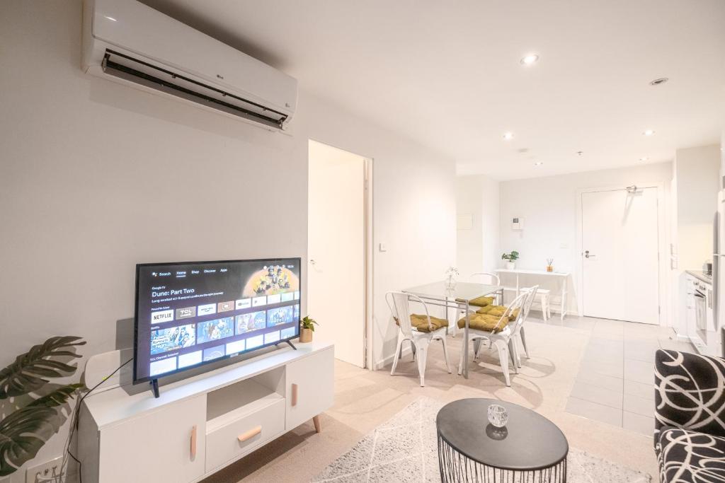 a living room with a flat screen tv on a white wall at 2br2ba Apartment Cbd Great Viewspoolgym in Melbourne