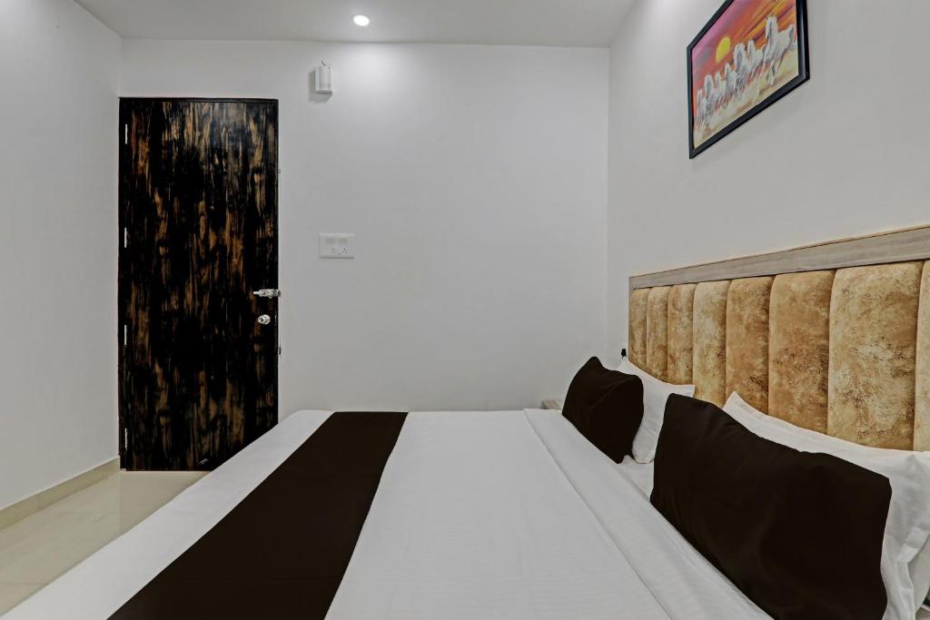 a bedroom with a bed with a black and white blanket at OYO Flagship THE VINDH in Gorakhpur