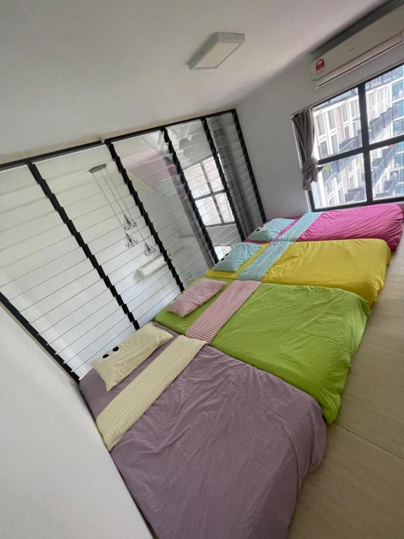 - une chambre avec un grand lit et des draps colorés dans l'établissement Cozy Party House in Damansara Perdana - Perfect Location, à Petaling Jaya