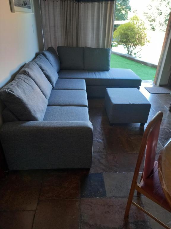 ein Wohnzimmer mit einem blauen Sofa und einem Tisch in der Unterkunft Rilli's Inn Apartment in Mtunzini
