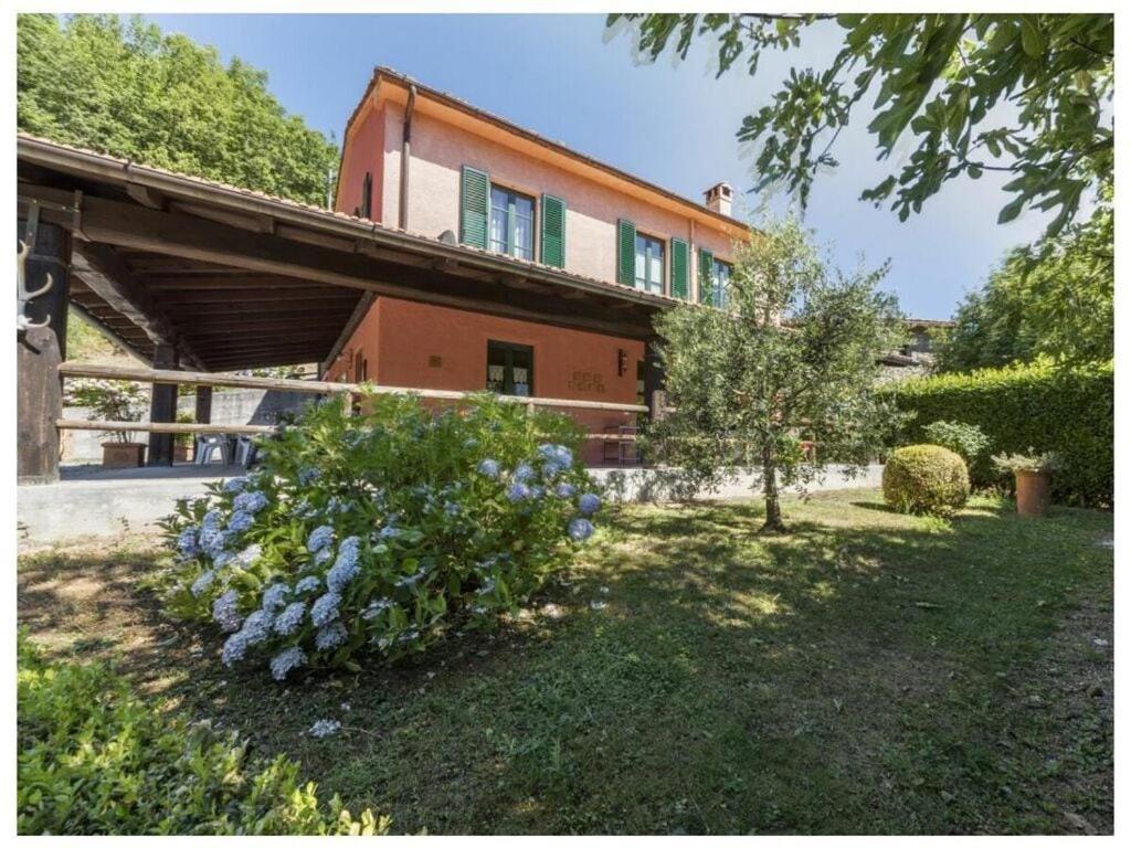 una casa con un ramo de flores en el patio en Villa Popiglio, en San Marcello Pistoiese