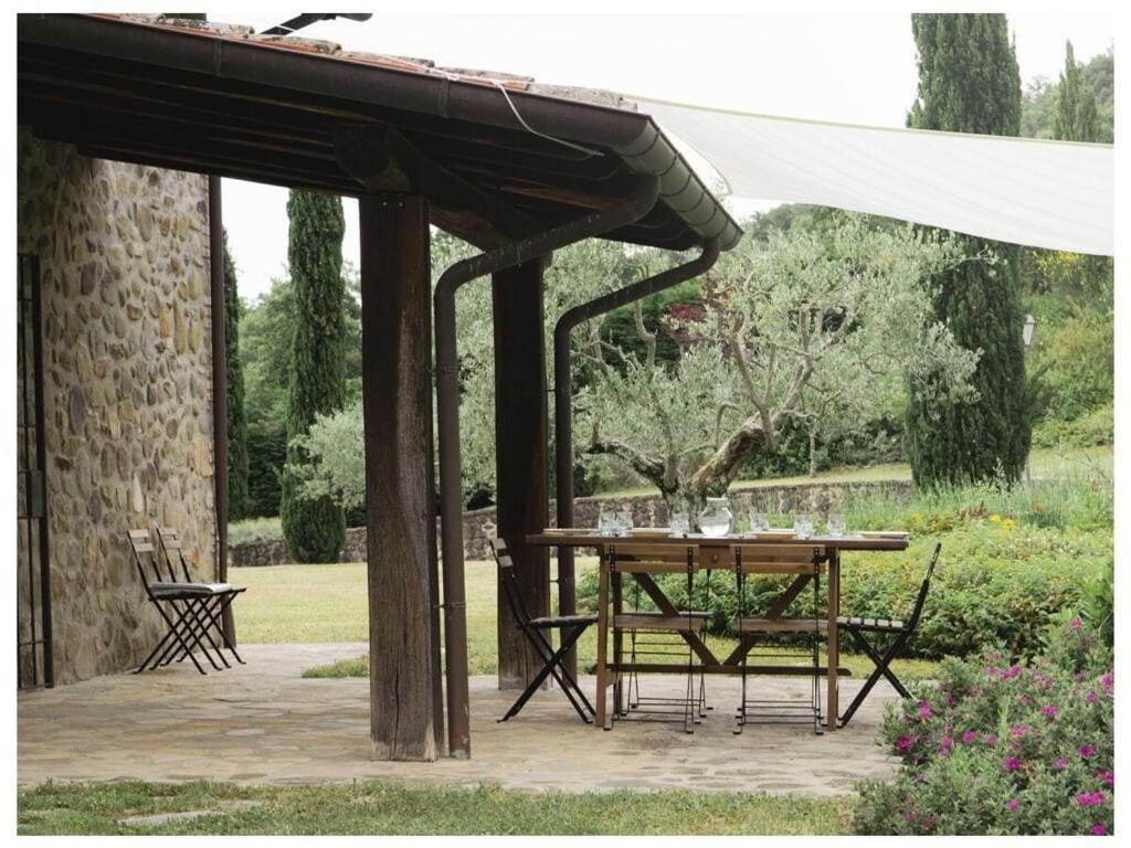 une table et des chaises en bois sous un auvent blanc dans l'établissement Villa Betta Comfortable holiday residence, à Città di Castello