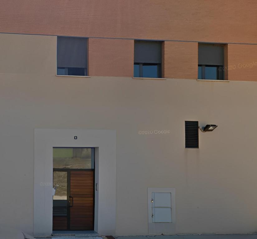 een wit gebouw met een deur aan de zijkant bij Apartamento Cattleya in Almazán