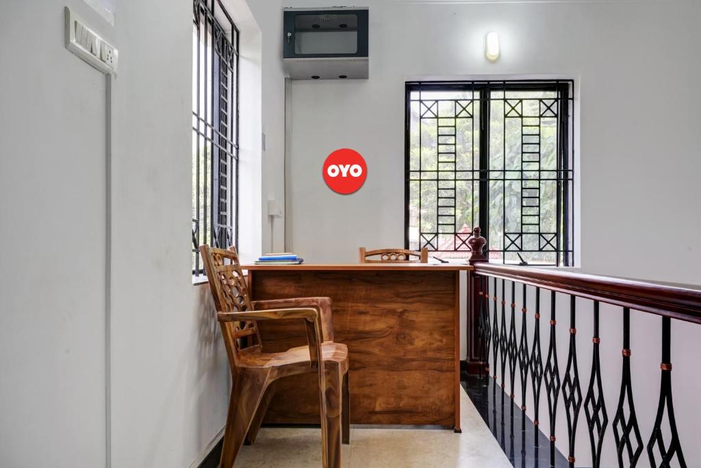 Elle comprend un balcon avec un bureau en bois et une chaise. dans l'établissement OYO Kakkanad Heights Inn, à Kakkanad