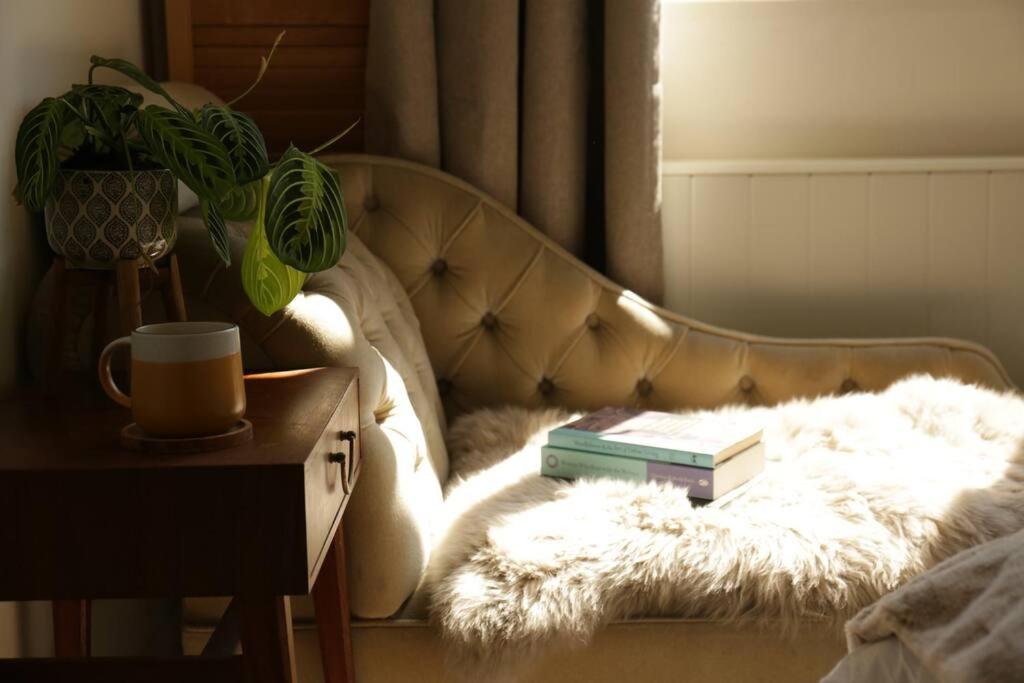 un sofá con dos libros encima en Sunny Seaside Sanctuary - Two Bedroom Apartment en Brighton & Hove