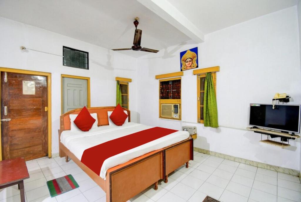1 dormitorio con 1 cama y TV de pantalla plana en Goroomgo Upasana Bhubaneswar, en Bhubaneshwar