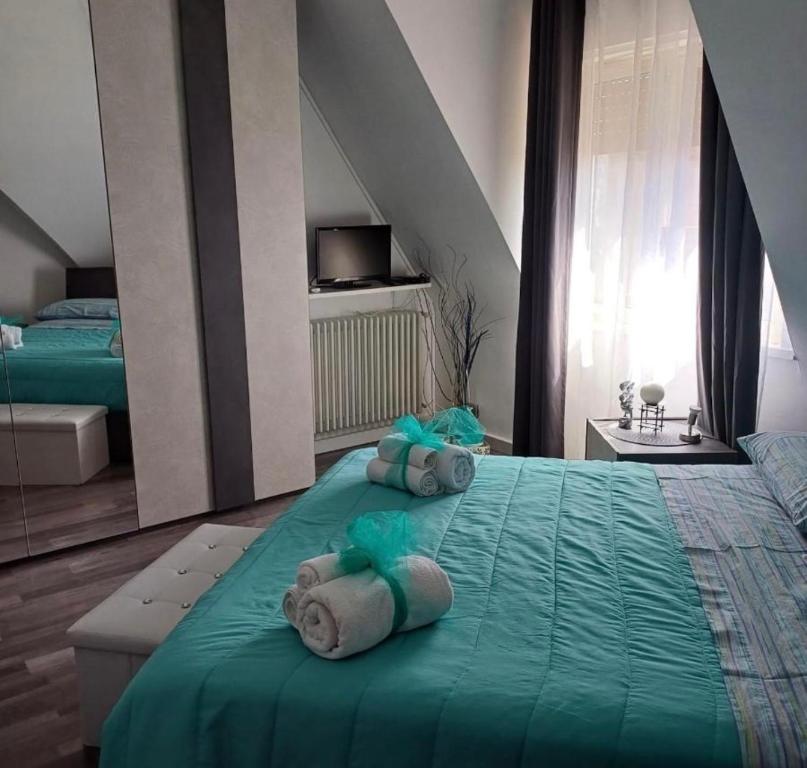 a bedroom with a green bed with towels on it at Casa vacanze Europa in Leonforte