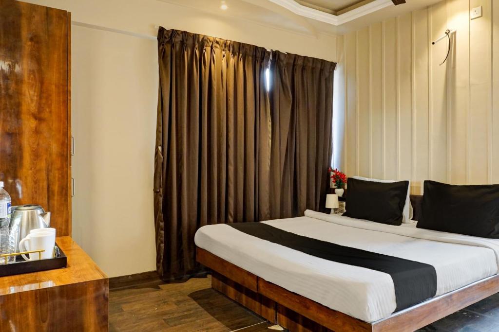 Un pat sau paturi într-o cameră la Collection O Hotel Nanashree Grand