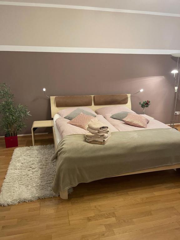 ein Schlafzimmer mit einem großen Bett mit rosa Kissen in der Unterkunft Stadtwohnung am Oertelplatz in München