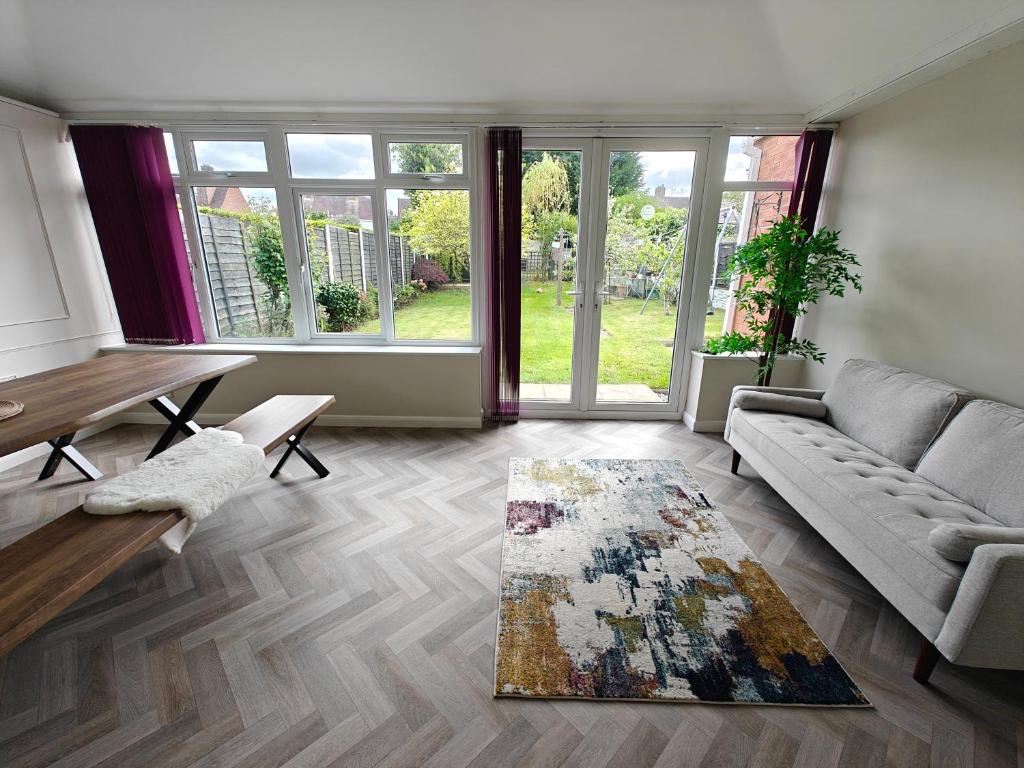 a living room with a couch and a table at 4 Bedroom Equipped House Driveway- 10 Mins to NEC JLR BHX HS2 & More- Birmingham Sutton Coldfield, Coleshill & More in Solihull