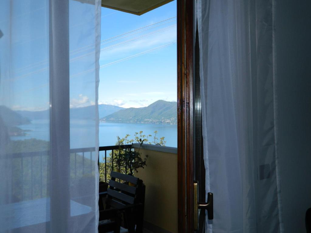 um quarto com uma janela com vista para a água em Lago Maggiore holiday house, lake view, Vignone em Dumenza