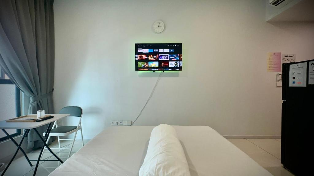 Habitación hospitalaria con cama, mesa y TV en Cozy Studio Kuala Lumpur by LH, en Kuala Lumpur
