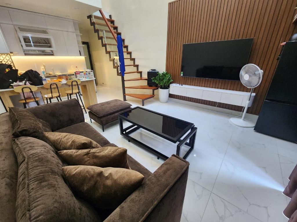 uma sala de estar com um sofá e uma televisão em Chapi’s Home em Ilha de Cát Bà