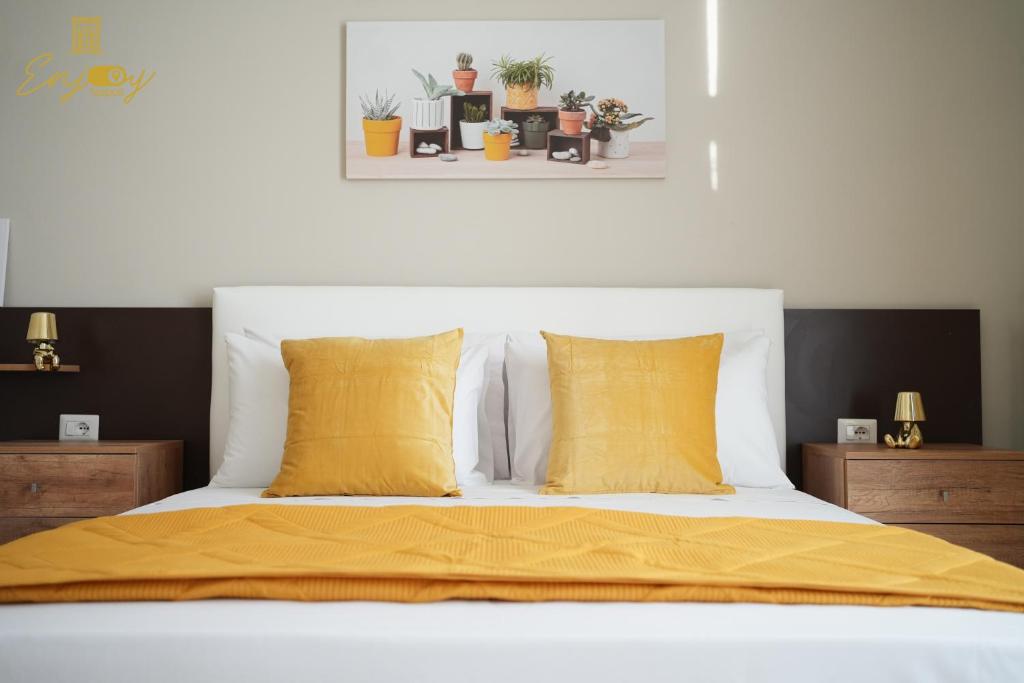 um quarto com uma cama com almofadas amarelas em ENJOY Napoli - Exclusive Apartment em Nápoles
