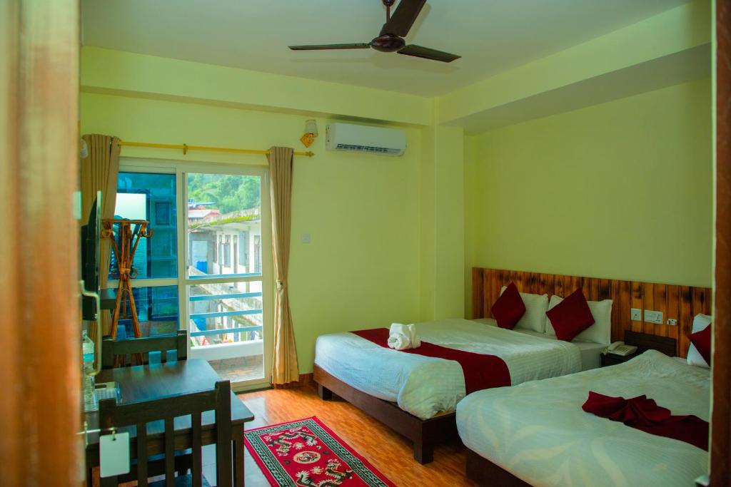 Rúm í herbergi á Hotel Pokhara Suites
