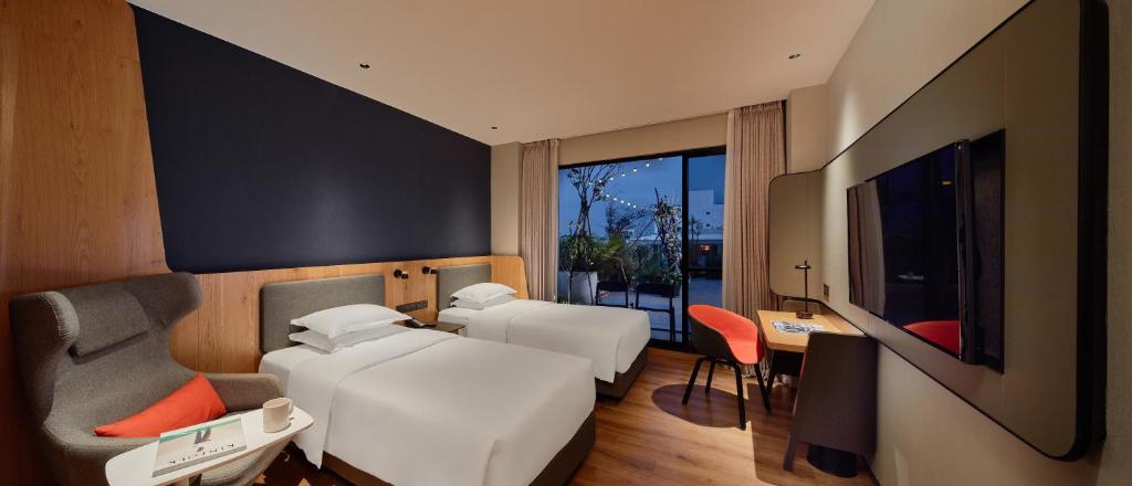 um quarto com 2 camas, uma secretária e uma televisão em Holiday Inn Express Chiayi, an IHG Hotel em Chiayi