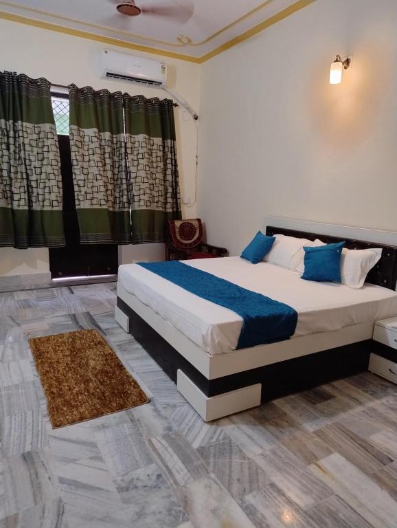 a bedroom with a large bed with blue pillows at Rani Villa Family HomeStay in Varanasi