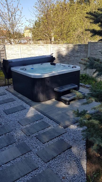 a hot tub sitting on top of a stone patio at Pueblo Apartamenty in Stegna