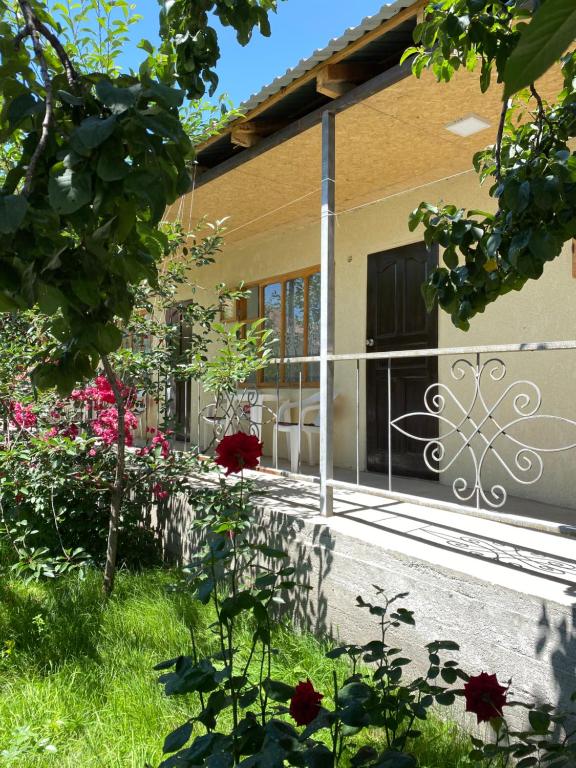 ein Haus mit einem Tor und Blumen im Hof in der Unterkunft У тети Сони in Tscholponata