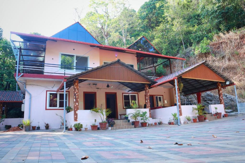 a house in the middle of a courtyard at Katakeri Deluxe Holiday Homes in Madikeri