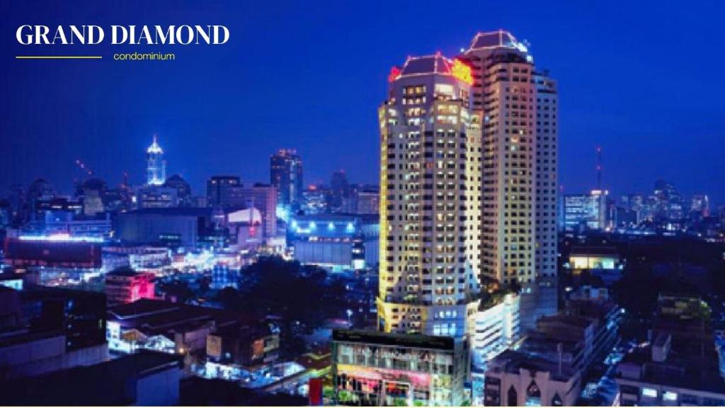 a city skyline at night with illuminated buildings at Grand Diamond Condo Suites in Bangkok