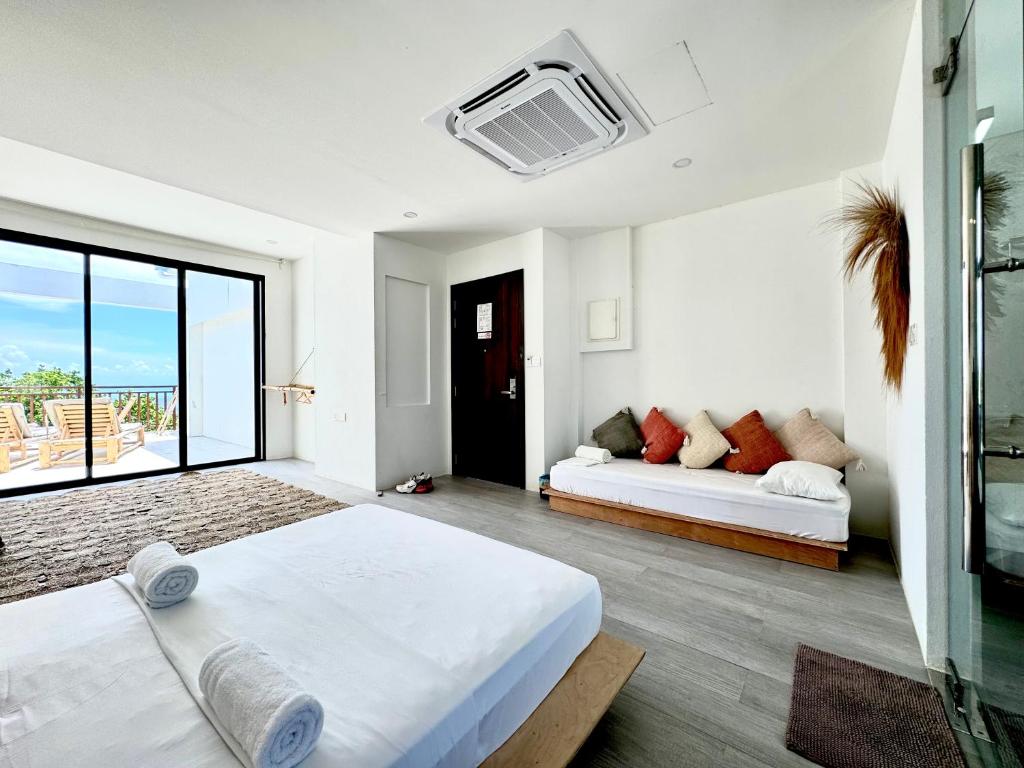 ein weißes Zimmer mit einem Bett und einem Sofa in der Unterkunft Samura Panorama Guest House in Thulusdhoo