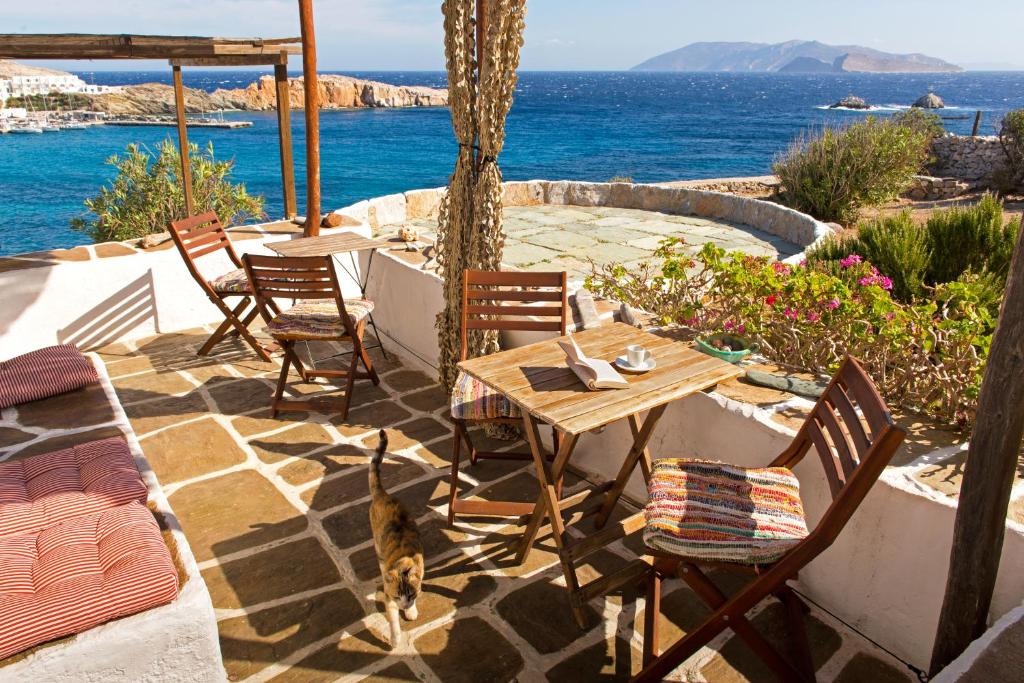 a patio with a table and chairs and a cat sitting on it at Alisideri Studios in Karavostasi