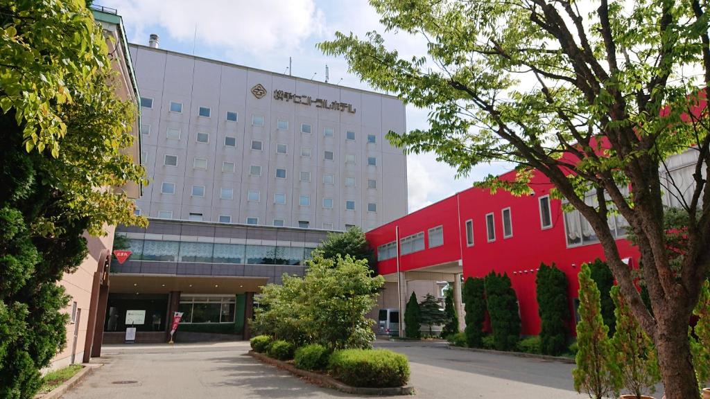 un hotel con un edificio rojo delante de él en Yokote Central Hotel, en Yokote