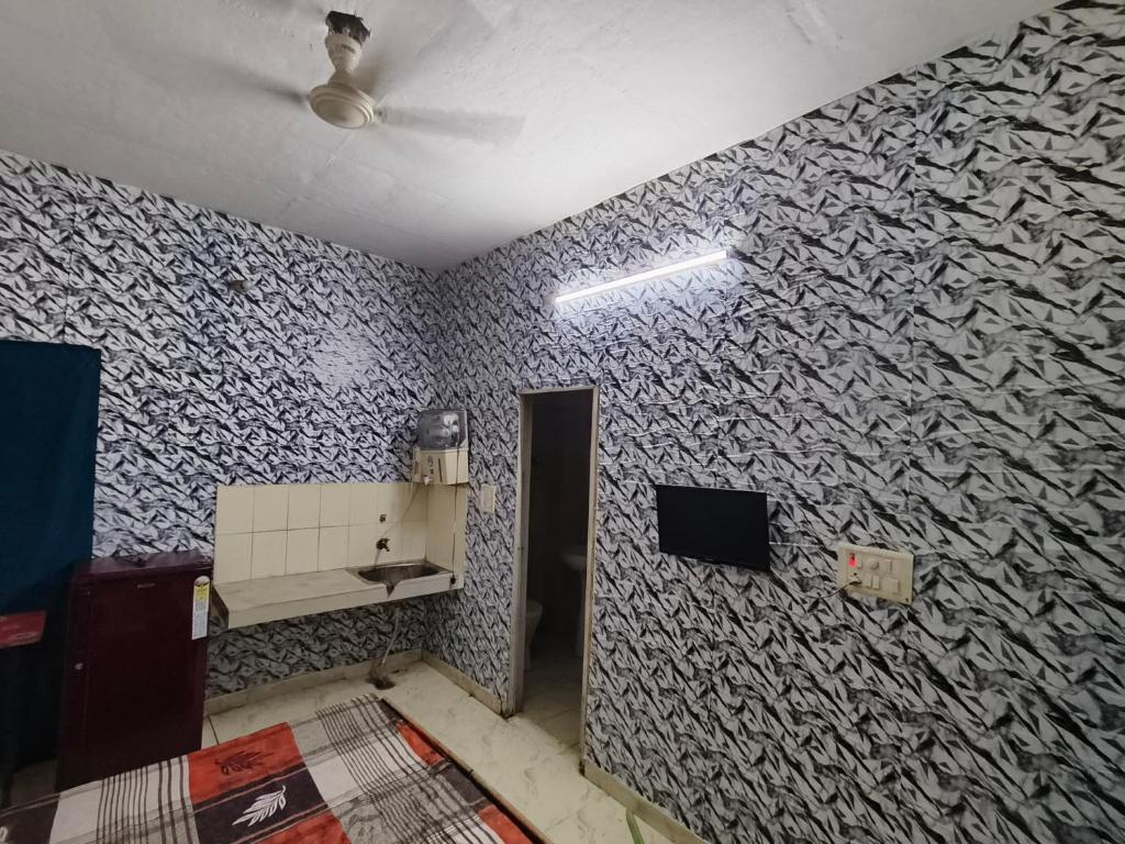 a room with a wall covered in wallpaper at KAMAL VILLA -- LPU Green Velly -- Super Deluxe Rooms in Phagwāra