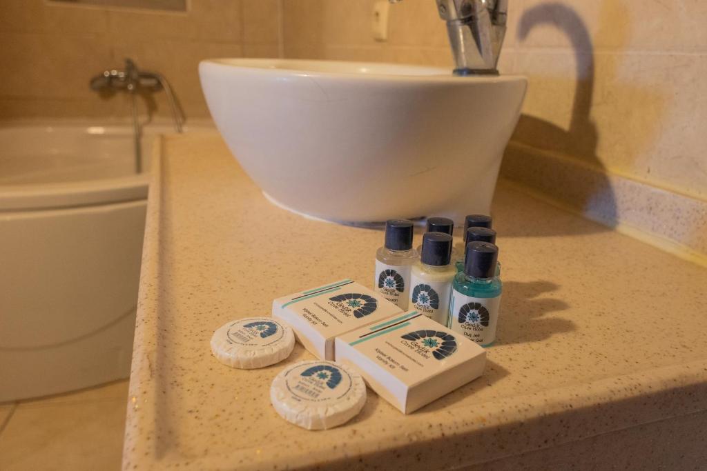 a bathroom counter with a sink and four bottles of soap at Gedik Cave Hotel in Göreme