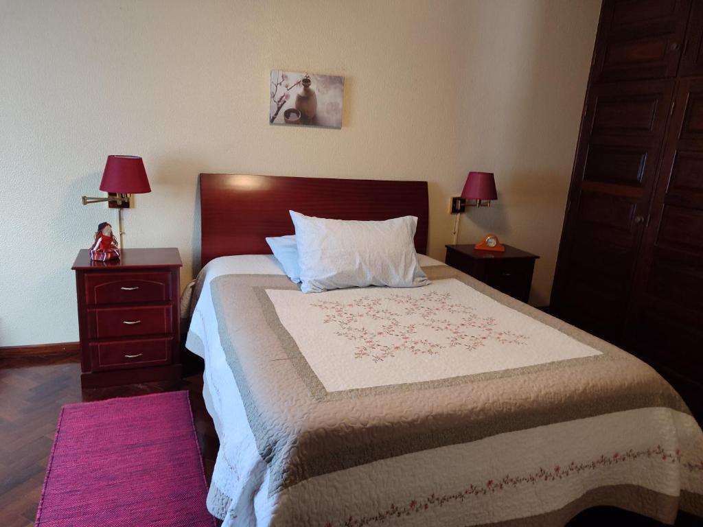 una camera da letto con un grande letto con due comodini di casa na Torre a Machico