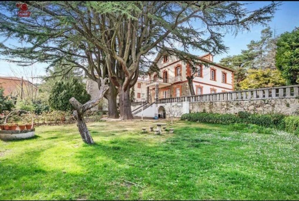 a large house with a tree and a fence at Acogedor chalet en la Sierra in Cercedilla