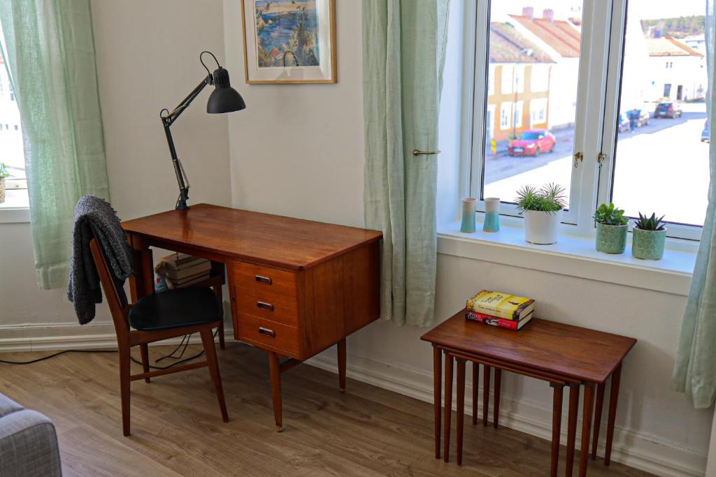 a desk with a lamp and a chair next to a window at Sentralt og romslig i Kristiansand sentrum in Kristiansand