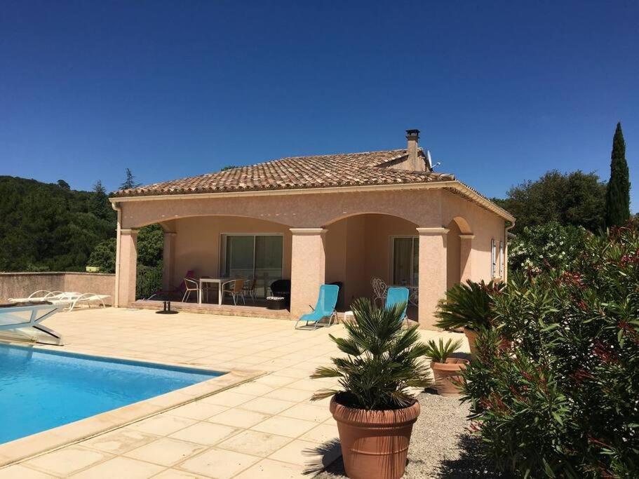 a villa with a swimming pool and a house at Au Murmure des Cascades in La Roque-sur-Cèze