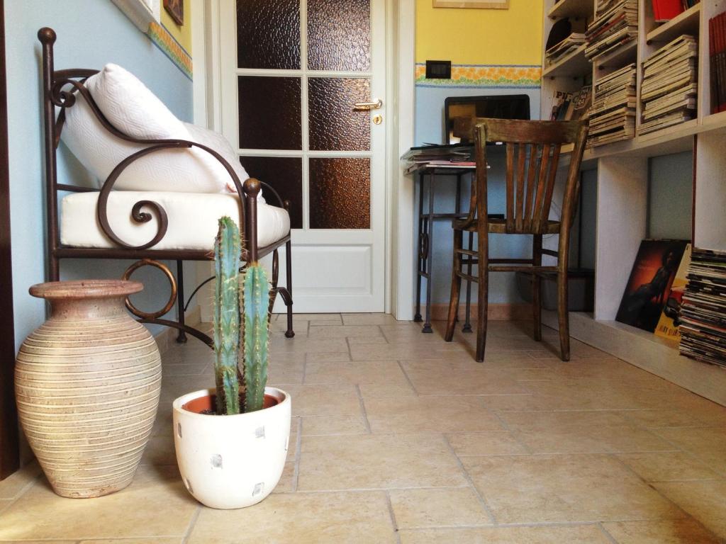 a room with a plant and a chair and a door at B&B Cheap Holidays in Sorso