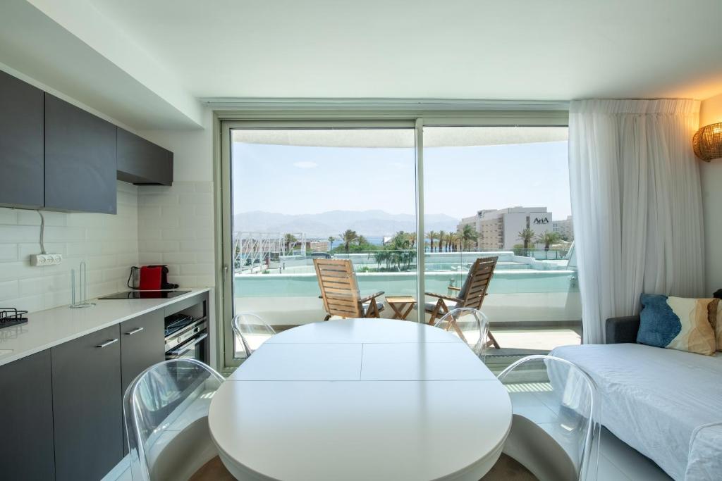 een keuken met een witte tafel en stoelen en een raam bij Sea Side Dream-Amazing sea view best location in town in Eilat