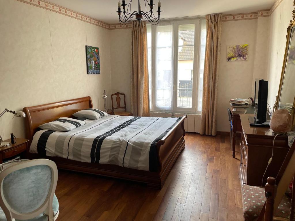 um quarto com uma cama, uma secretária e uma televisão em Joli studio indépendant et jardin em Saint-Prix